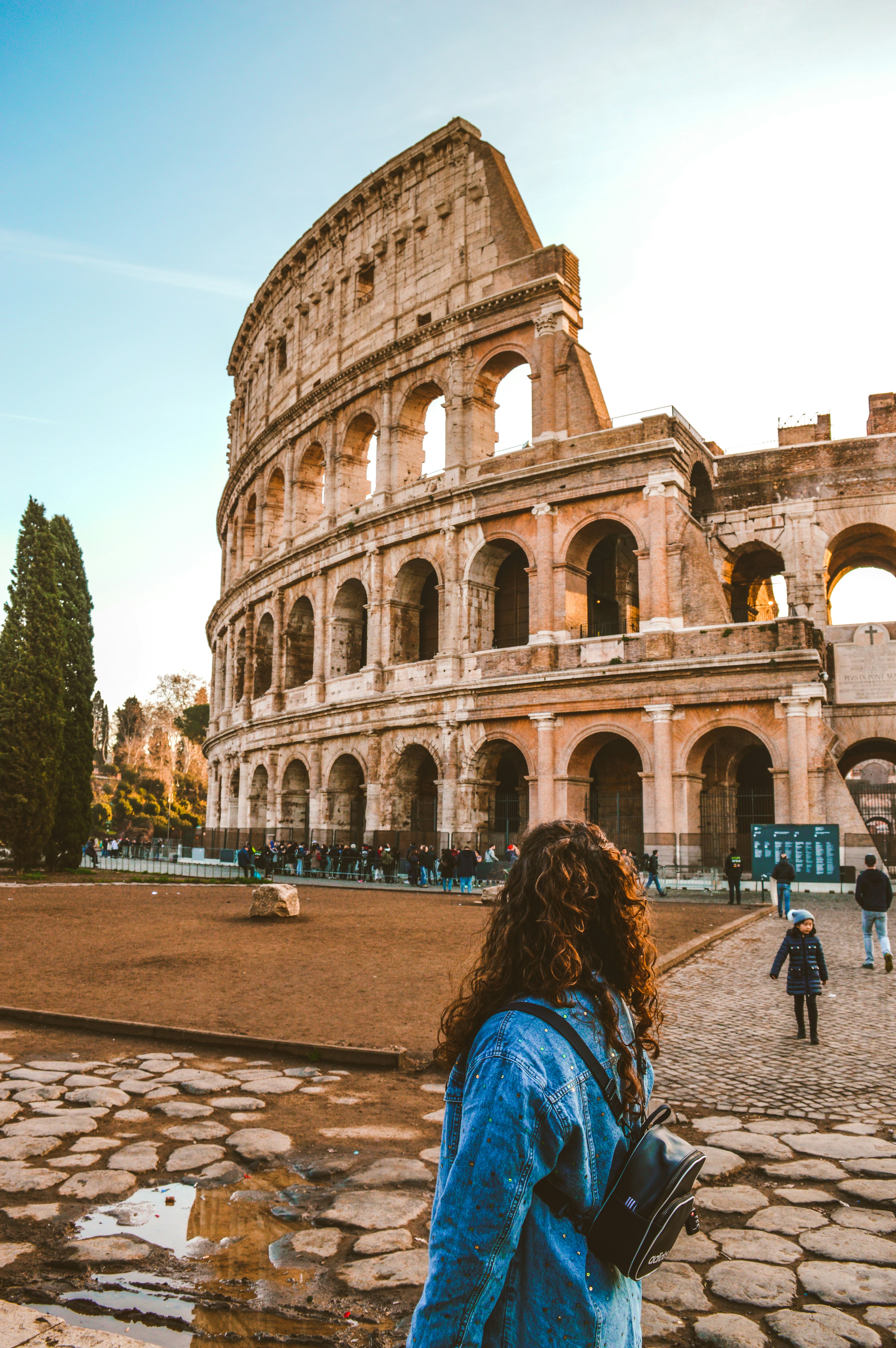 A woman standing in front of the Colosseum in Rome